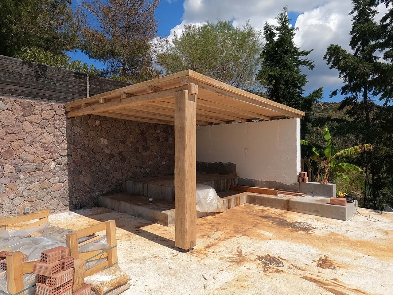 Κατασκευή πέργκολας με ακανόνιστη ξυλεία καστανιάς και τοποθέτηση καλαμωτής για σκίαση στην Αίγινα